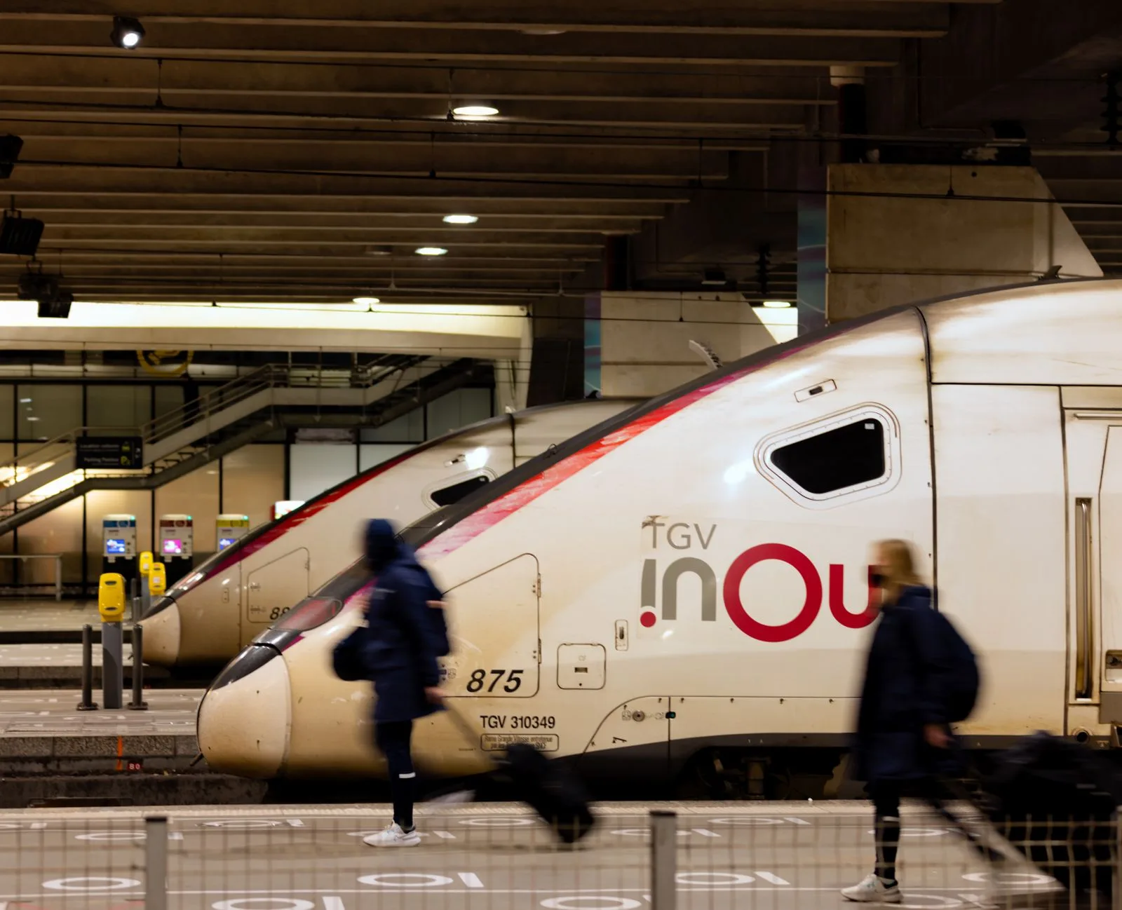 Rame de TGV INOUI à quai dans une gare française, des voyageurs passant le long du quai
