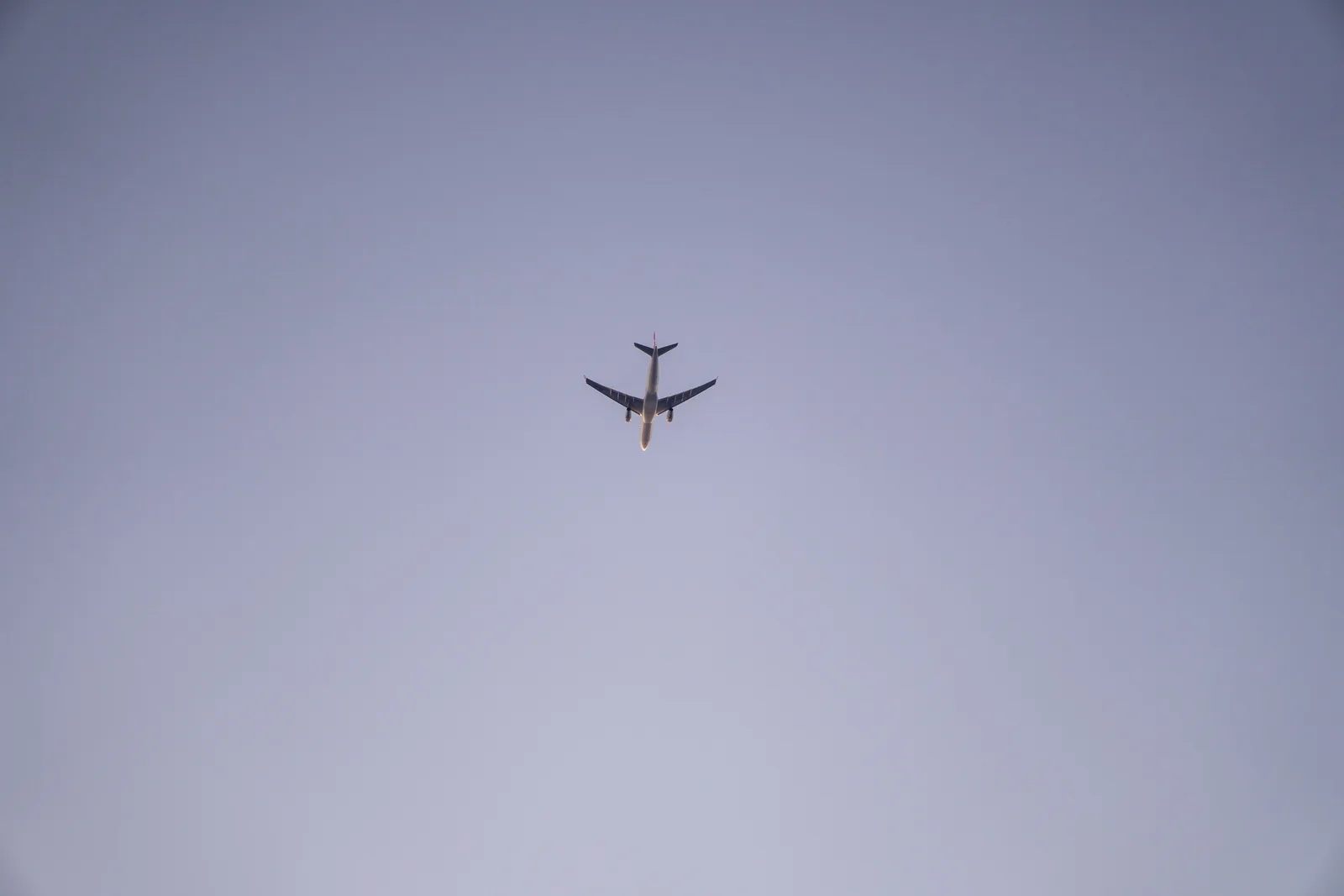 Avion de ligne en vol vu d'en dessous dans un ciel dégagé