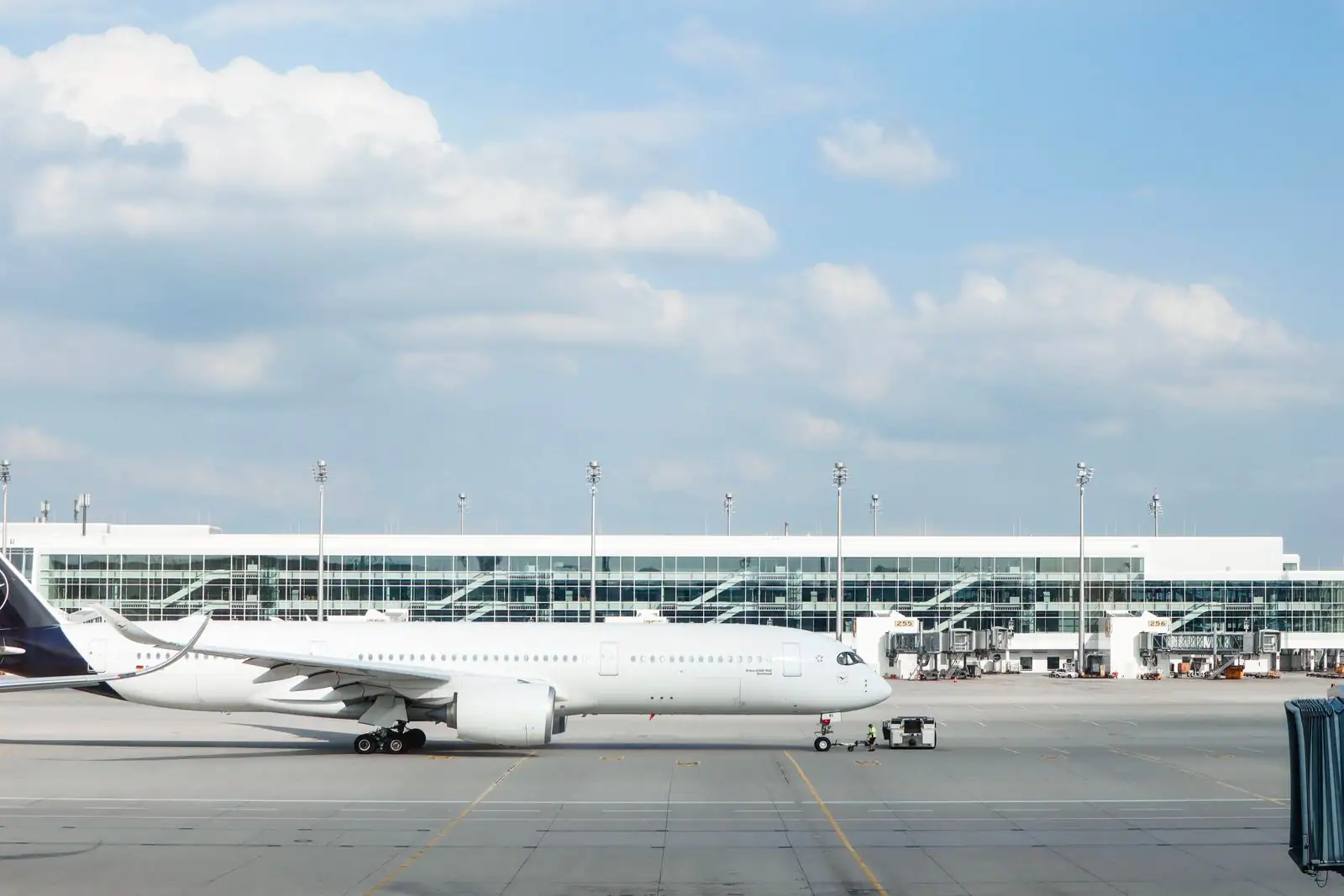 Avion de ligne commercial blanc stationné sur le tarmac devant un terminal d'aéroport