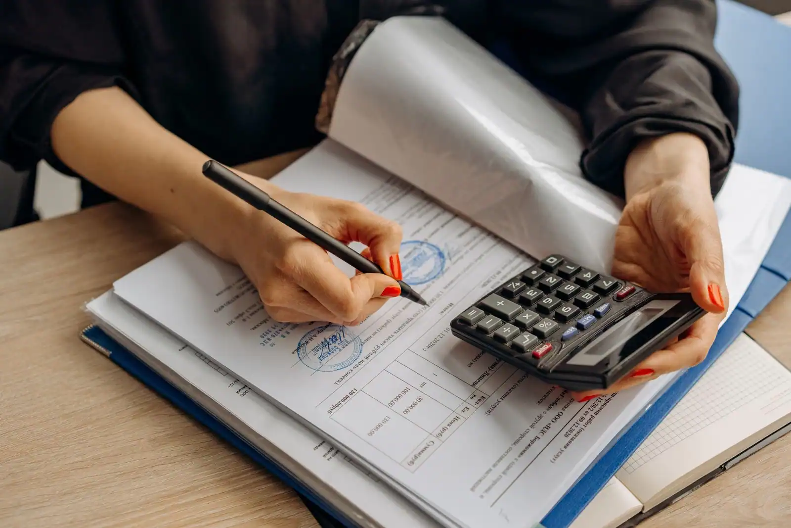 Personne comparant des documents de prêt et d'assurance avec une calculatrice