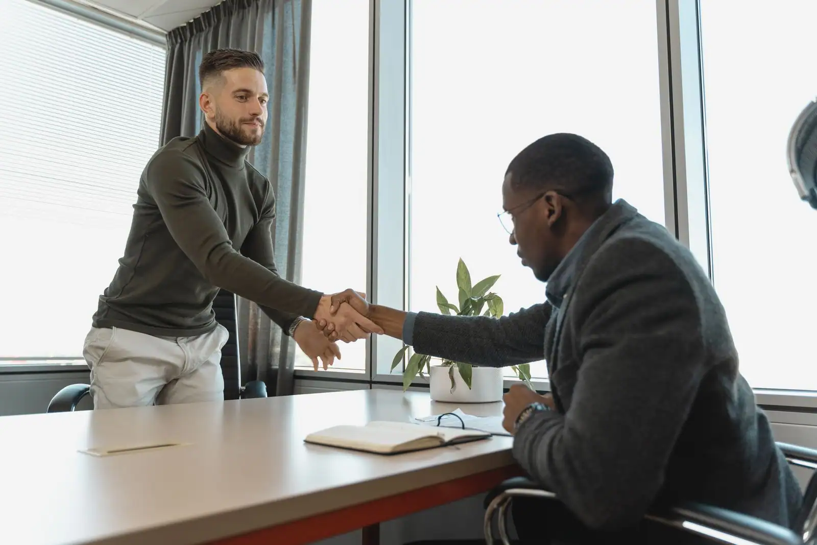 Poignée de main lors d un entretien d embauche dans un bureau, entre deux personnes