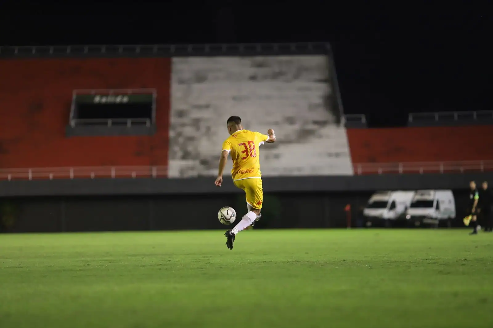 Footballeur contrôlant le ballon sur la pelouse d'un stade