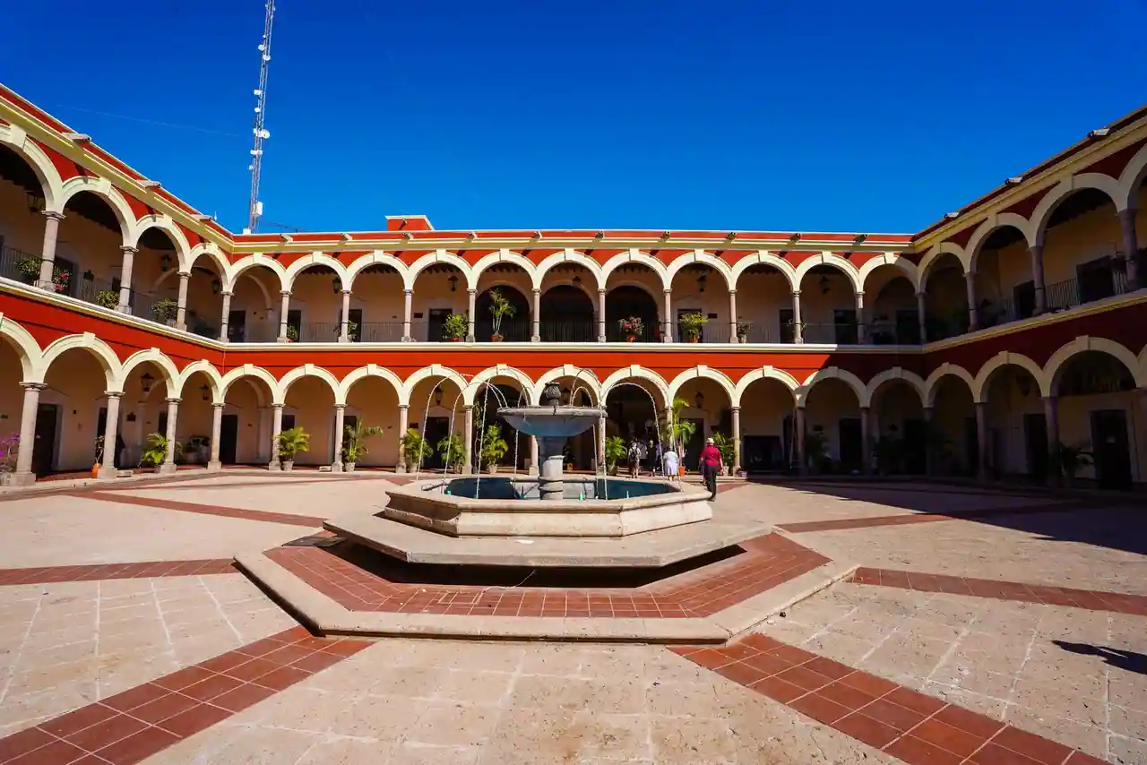 Cour intérieure à arcades d'un édifice colonial mexicain aux tons ocre et crème
