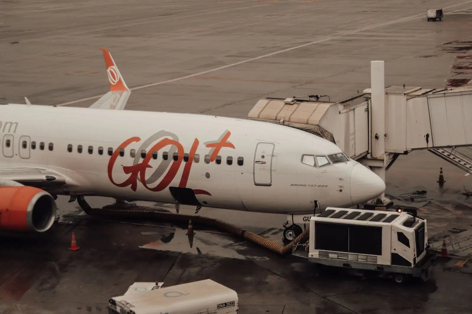 Avion de ligne stationné près d'une passerelle d'embarquement sur le tarmac d'un aéroport