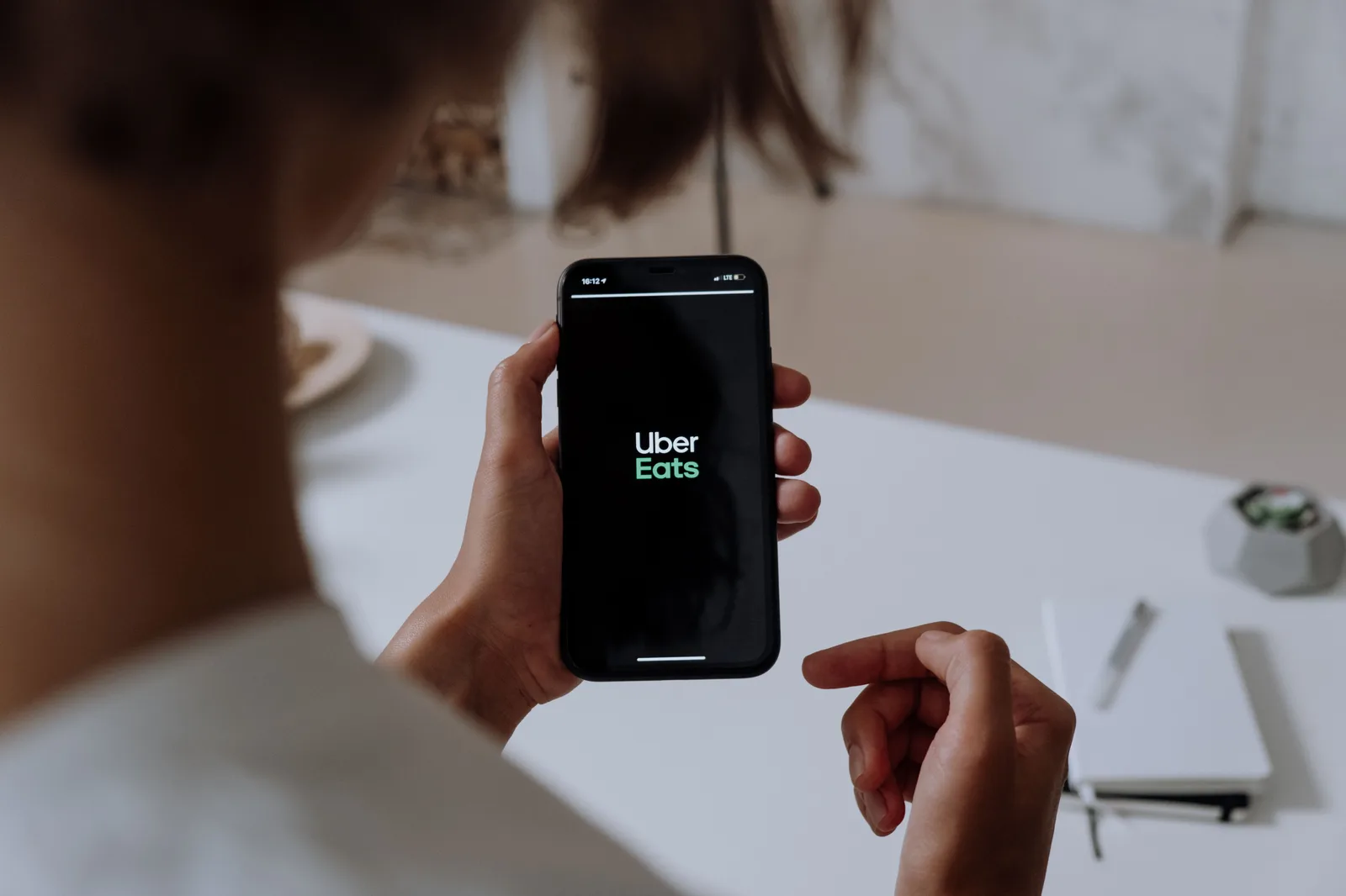 Personne tenant un smartphone affichant l'application de livraison de repas Uber Eats