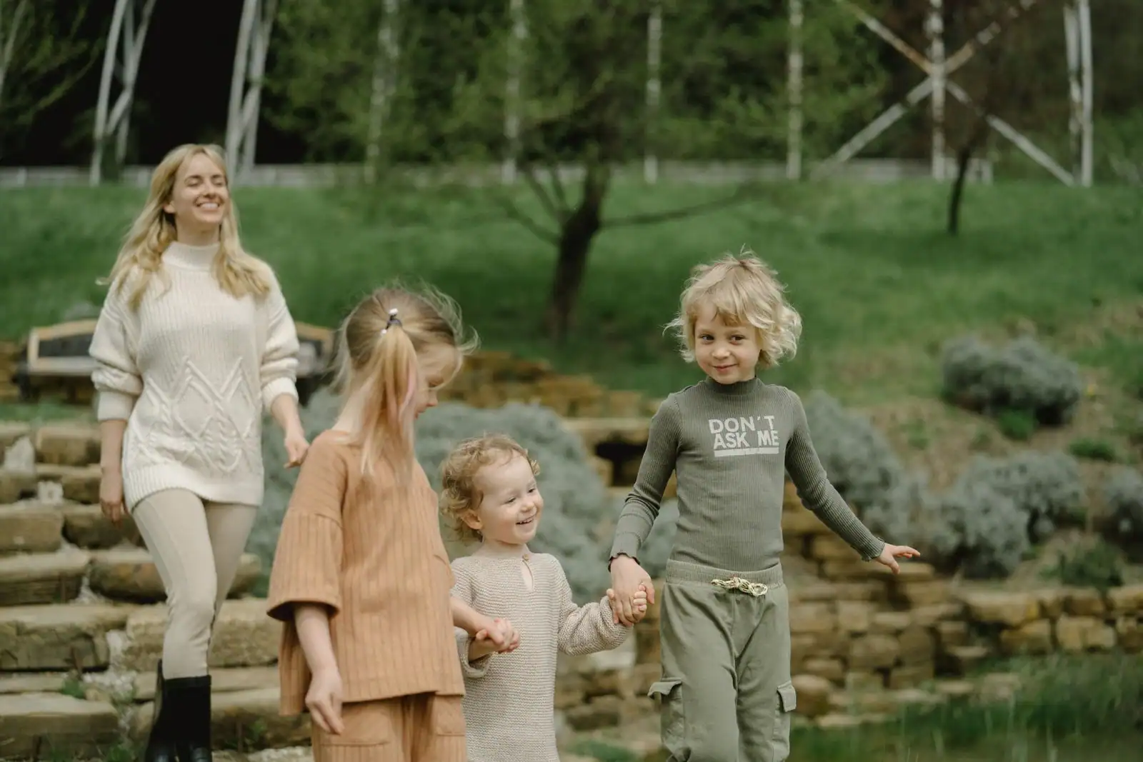 Famille avec enfants se promenant dans un parc public verdoyant lors d'une sortie.