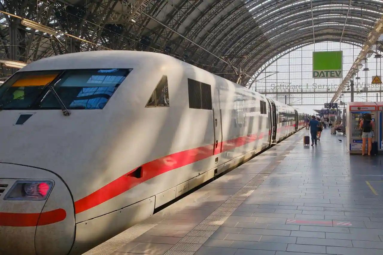 Train à grande vitesse à quai dans une gare, voyageurs sur le quai