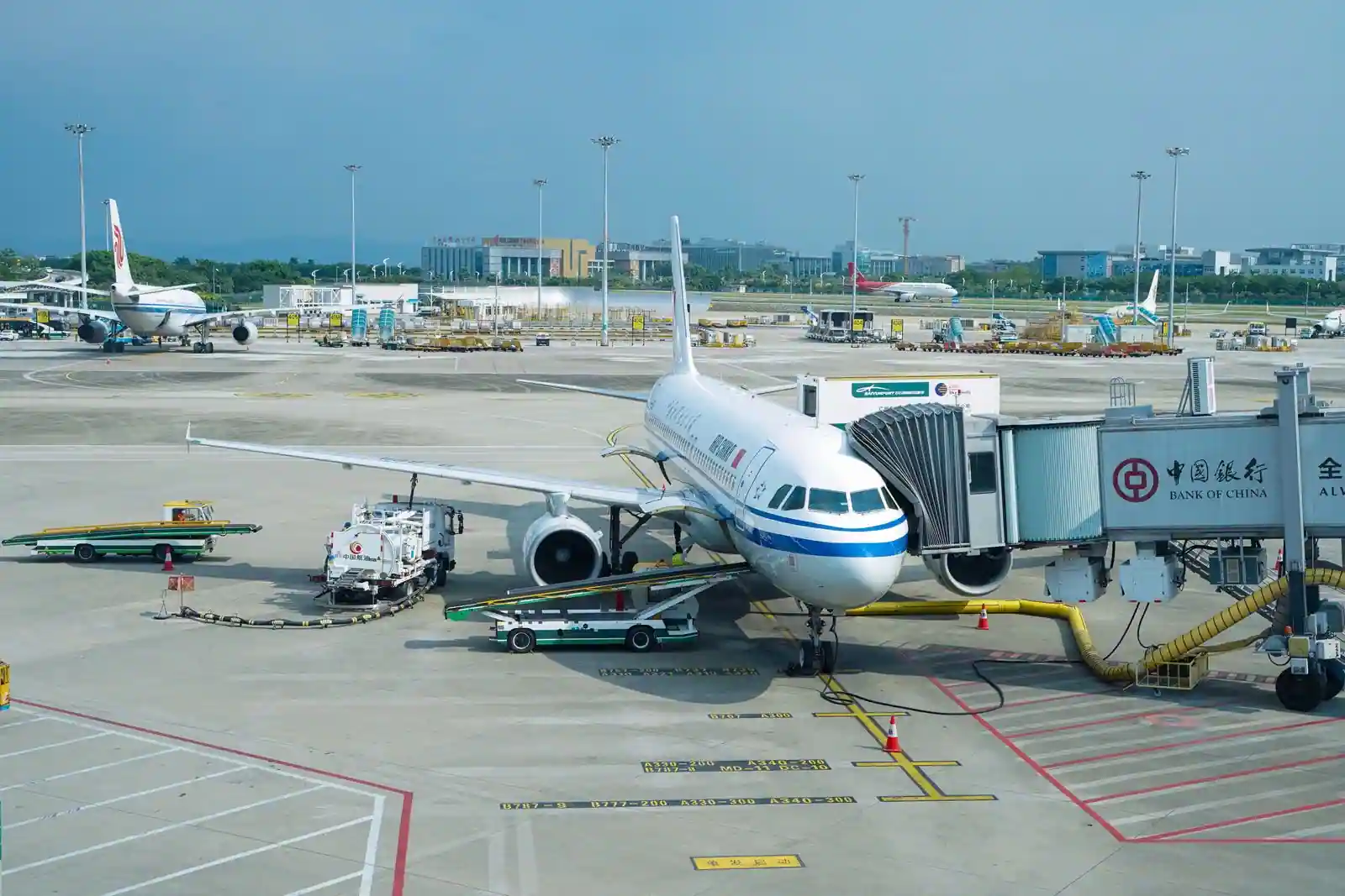 Avion de ligne relié à une passerelle d'embarquement sur le tarmac d'un aéroport international