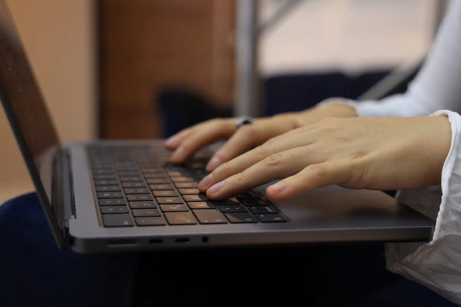 Mains d'une personne en train de taper sur le clavier d'un ordinateur portable