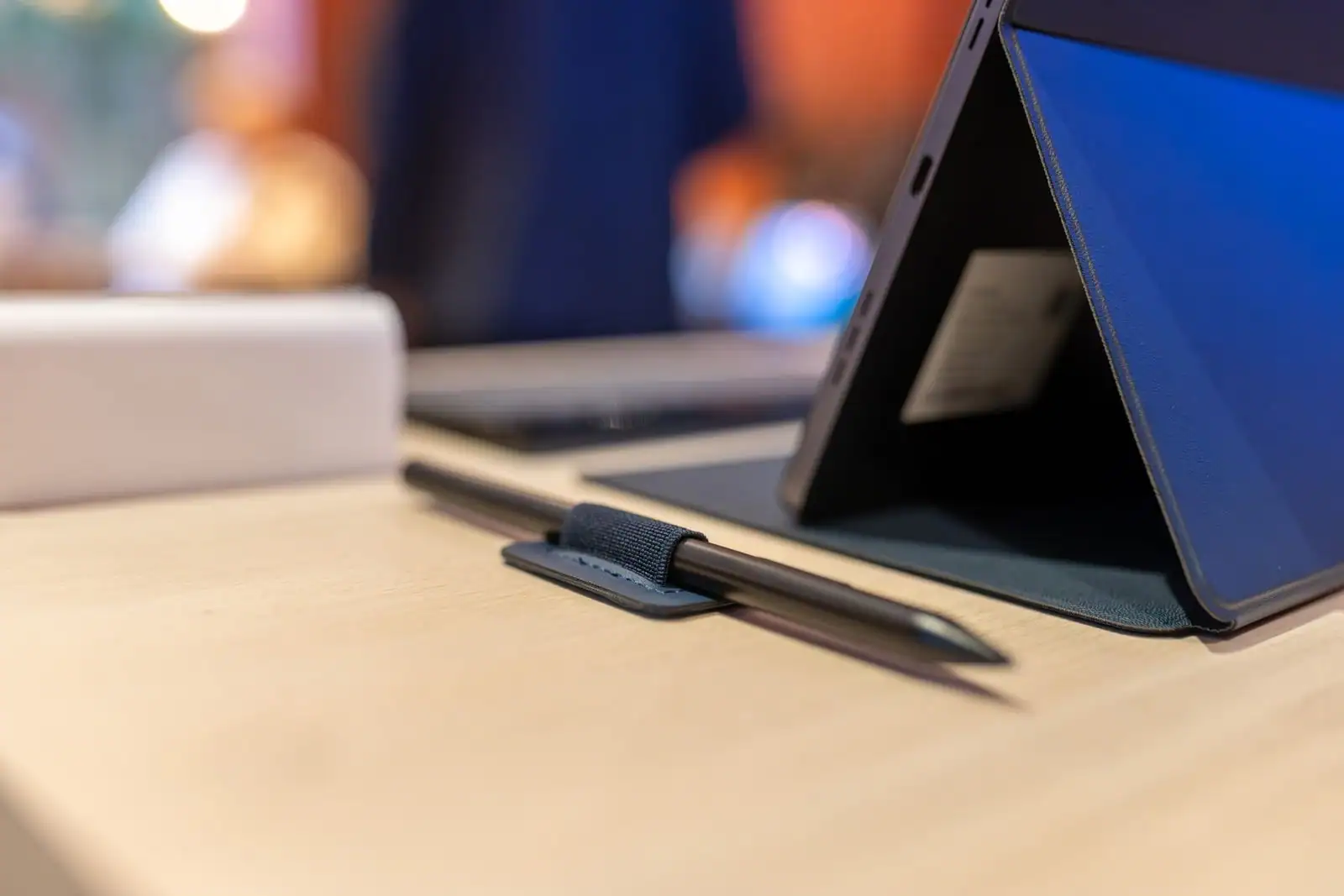 Tablette tactile posée sur un bureau dans son étui, un stylet rangé dans sa boucle