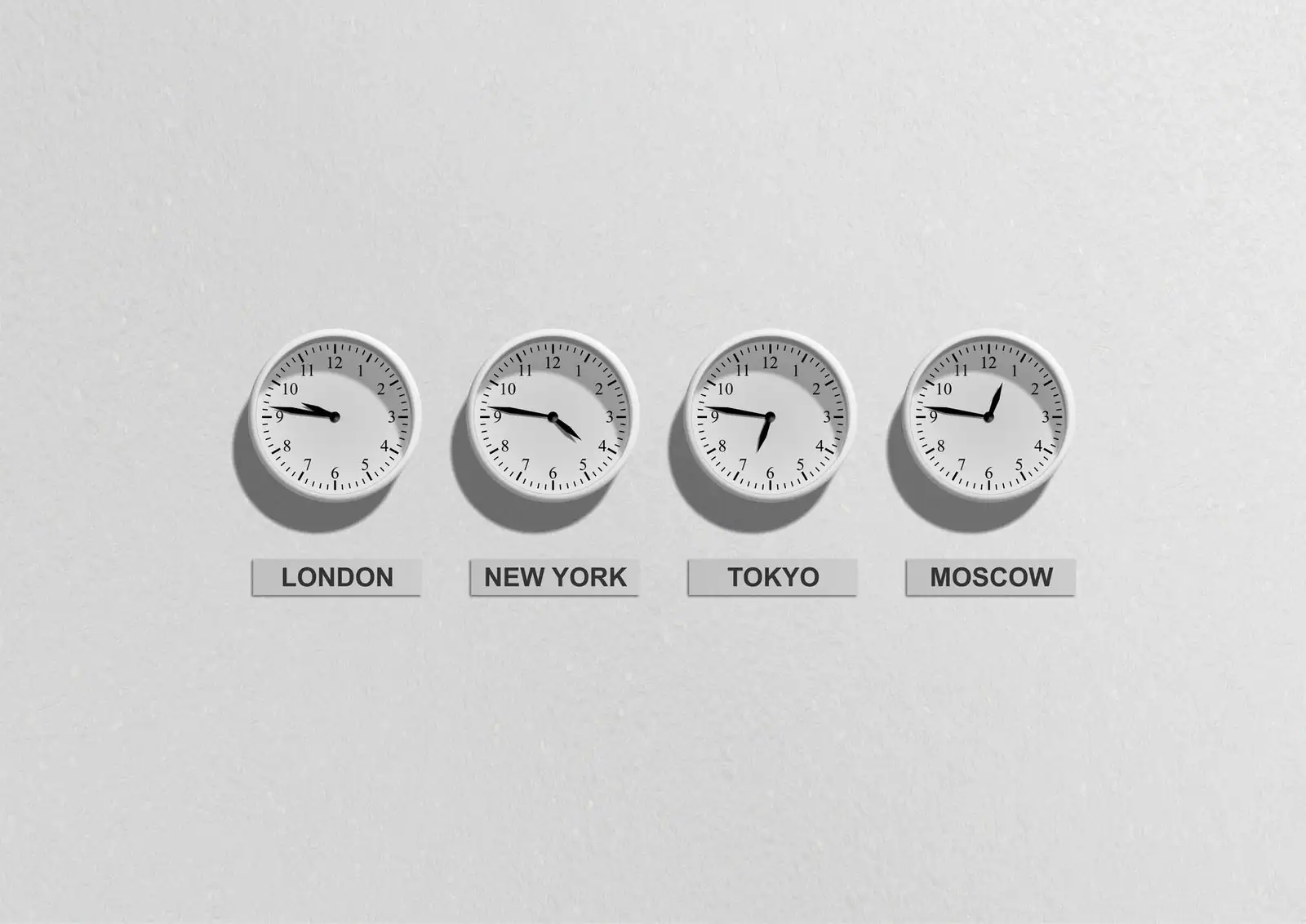 Quatre horloges murales étiquetées Londres, New York, Tokyo et Moscou, affichant des heures différentes