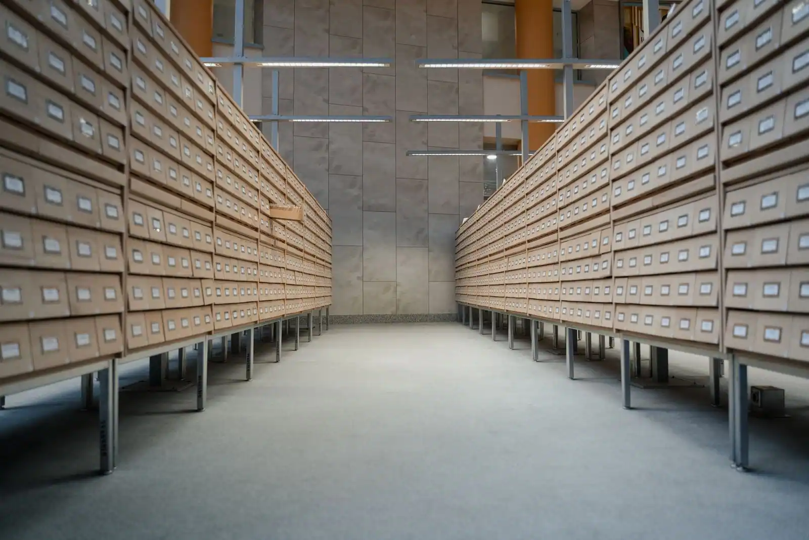 Rangées de tiroirs d'un fichier de bibliothèque alignées dans une salle d'archives déserte.