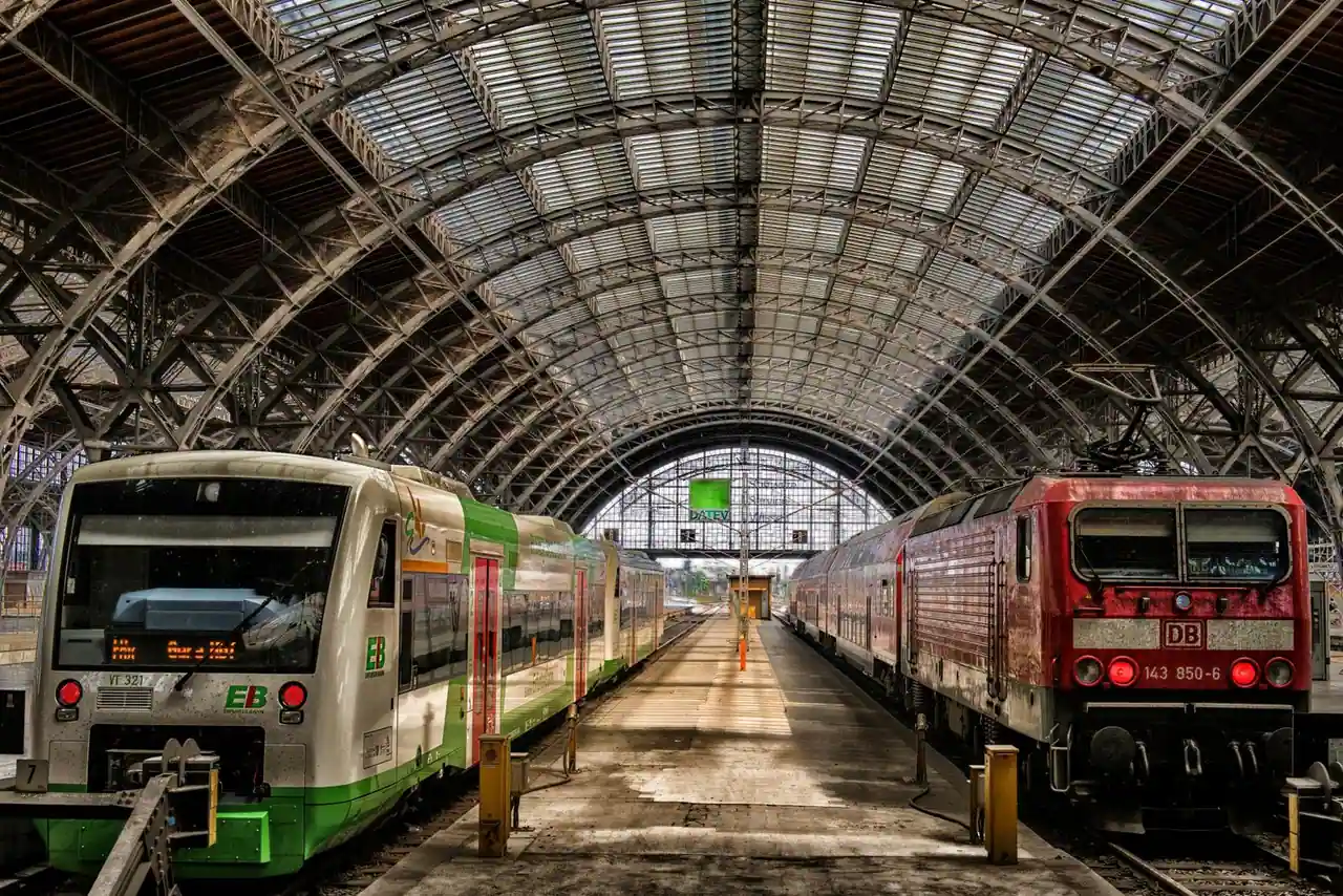 Trains régionaux face à face de part et d'autre d'un quai, sous la verrière métallique d'une gare allemande